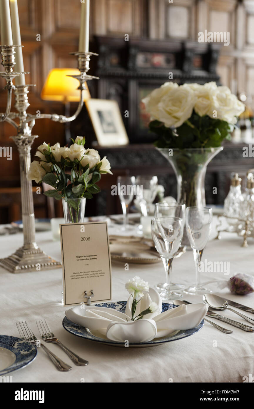 The Dining Room Table Laid With Candles And Seasonal Flowers