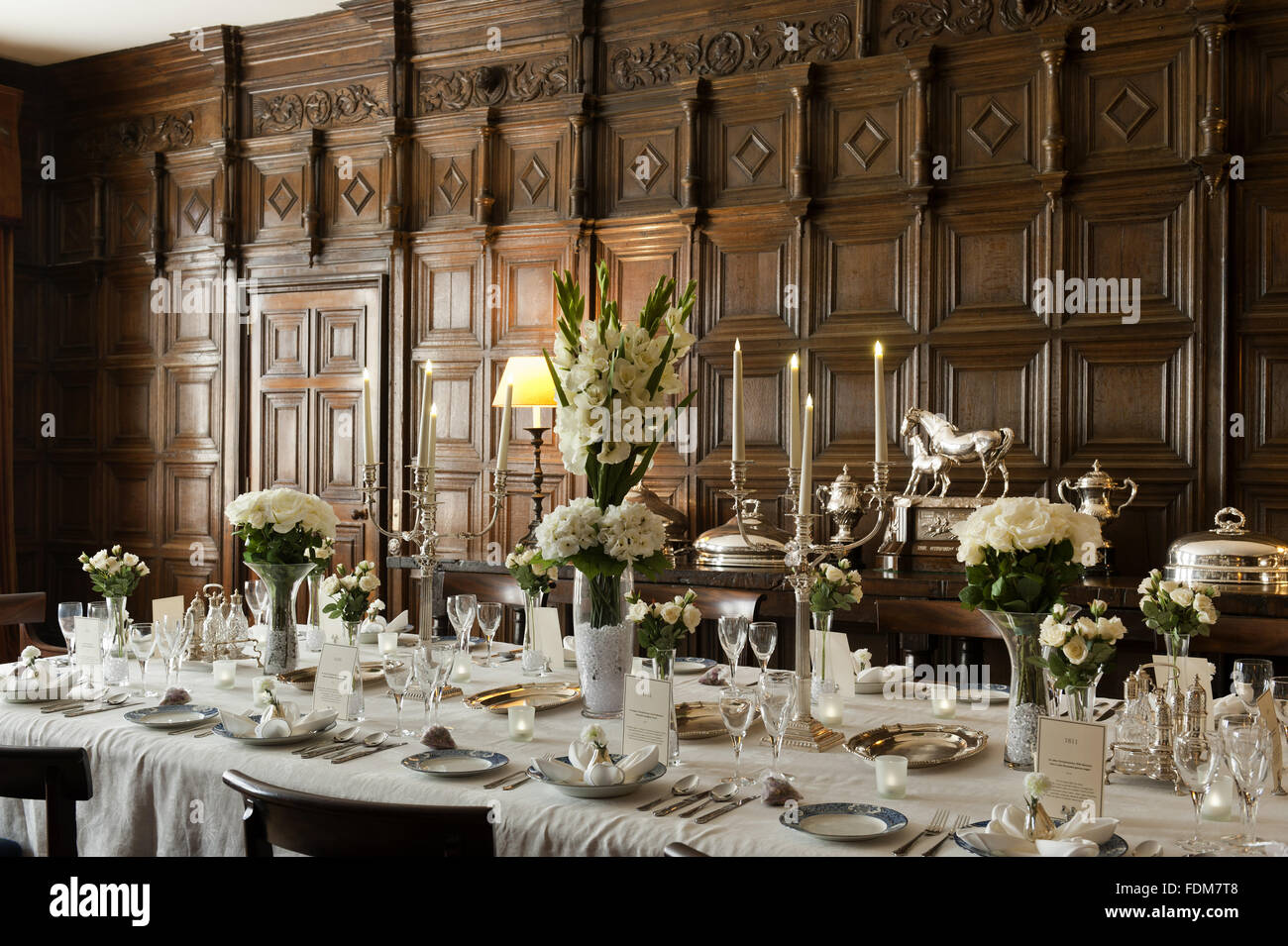 The Dining Room Table Laid With Candles And Seasonal Flowers At