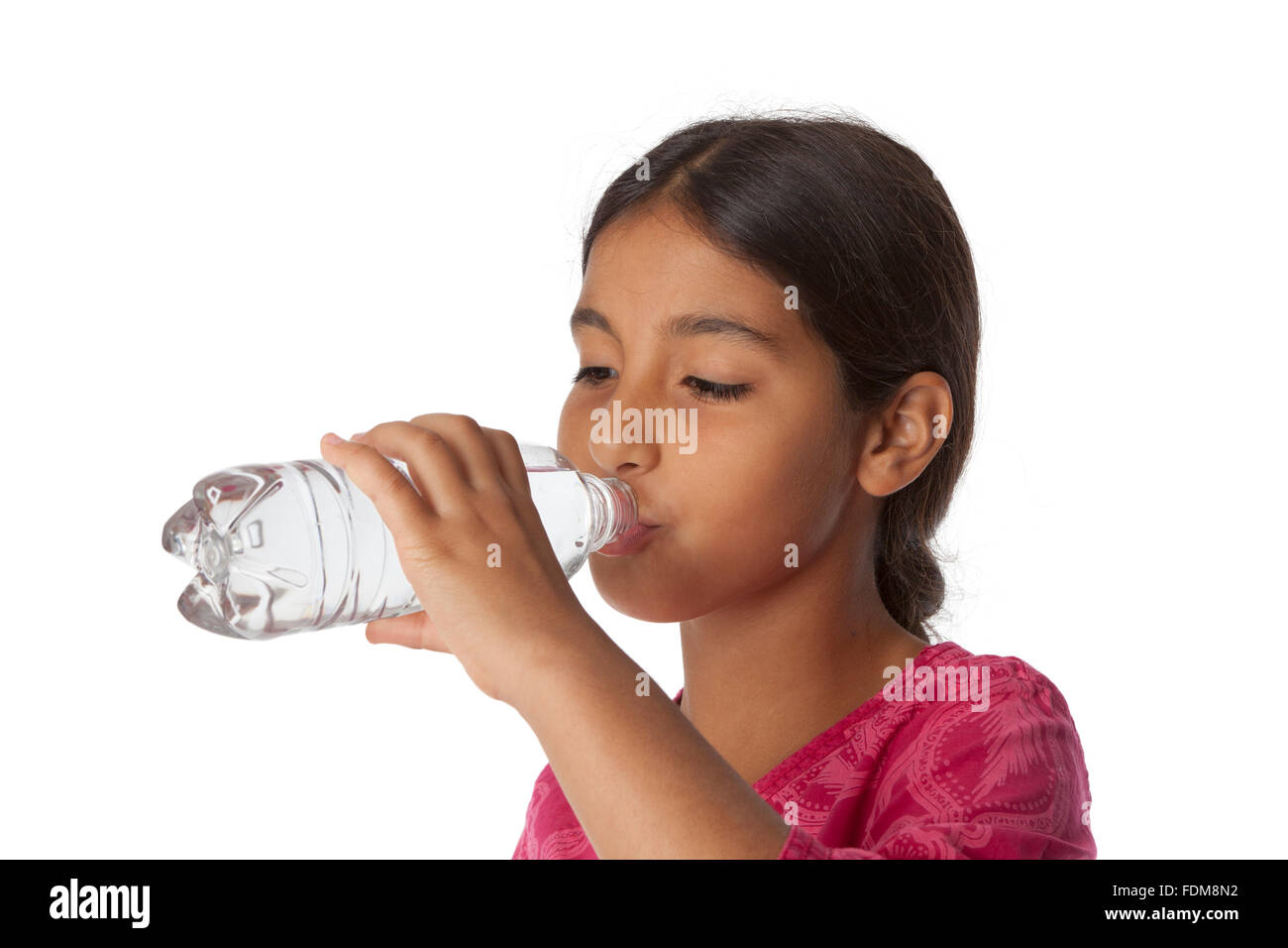 Young teenage girl drinking fresh water from a bottle on white background Stock Photo