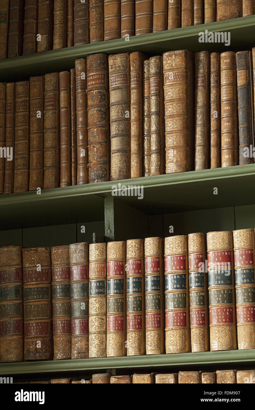 Books on bookshelves in the Study at Belton House, Lincolnshire. The books are dummies, with joking titles such as 'Paradise Improved' and 'Law without Fees'. Stock Photo