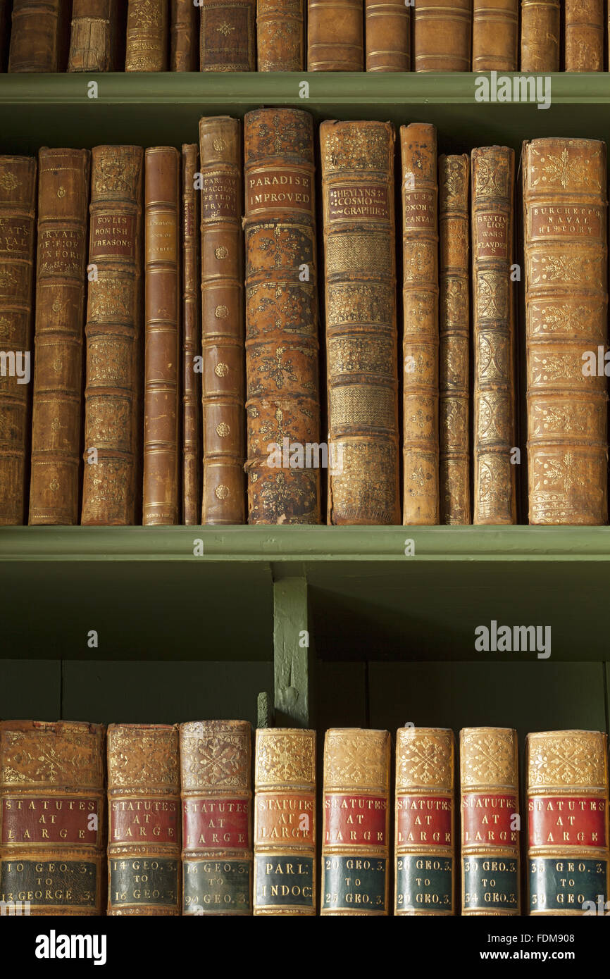 Books on bookshelves in the Study at Belton House, Lincolnshire. The books are dummies, with joking titles such as 'Paradise Improved' and 'Law without Fees'. Stock Photo