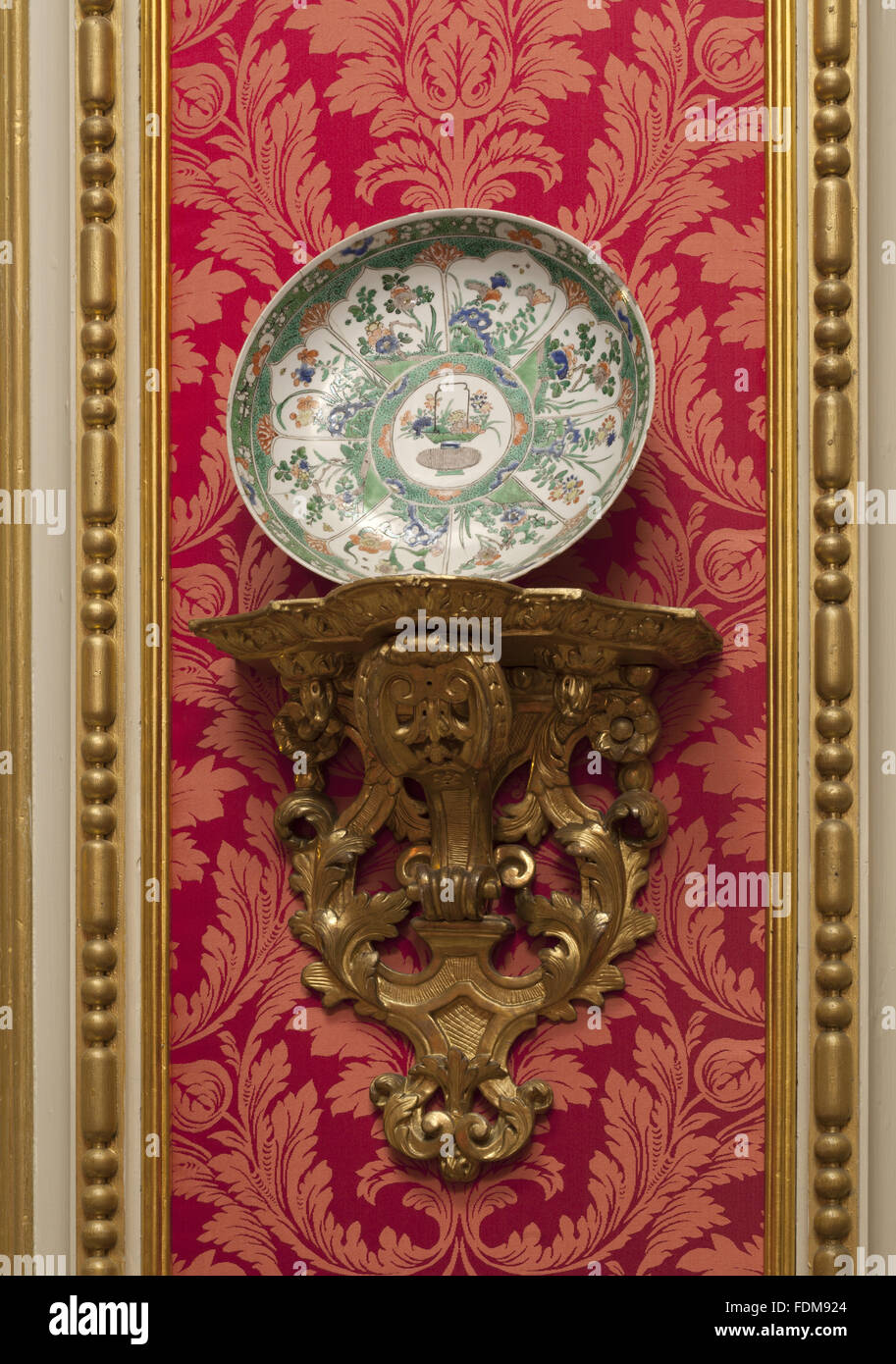 One of a pair of famille verte dishes on a giltwood wall bracket in the Red Drawing Room at Belton House, Lincolnshire. National Trust Inventory number: 433401. Stock Photo