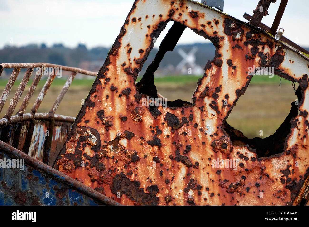 view of cley mill through window of old rusted boat wreck, north norfolk, england Stock Photo