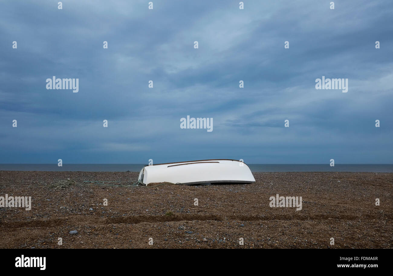 upturned white boat on cley beach, north norfolk, england Stock Photo