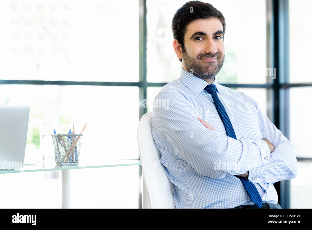 Young businessman in office standing and smiling Stock Photo - Alamy