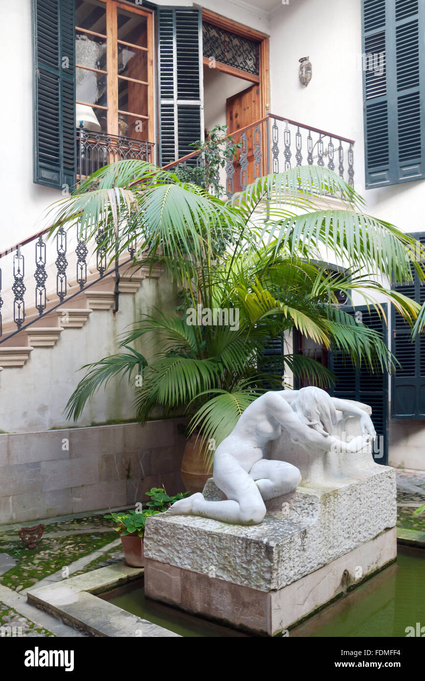 Entrance to Museum of Joaquim Torrents Llado with classical marble sculpture and palm trees in Palma de Malllorca, Spain Stock Photo