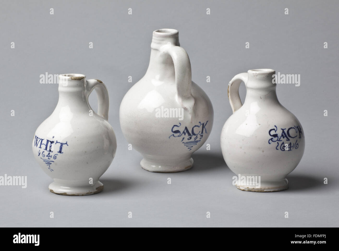 Seventeenth century sherry jugs inscribed 'SACK 1643'. A set of three English tin glazed earthenware wine bottles/jugs, with bulbous bodies and staright necks at Cotehele, Cornwall. Stock Photo