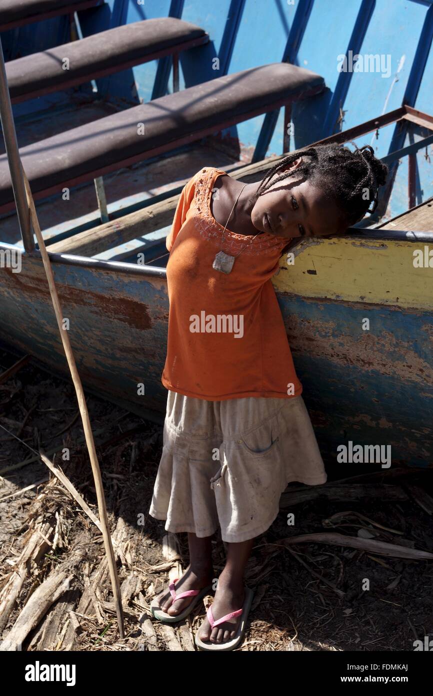 A young girl stands next to her fathers boat near a jetty at Lake Chamo,Ethiopia Stock Photo