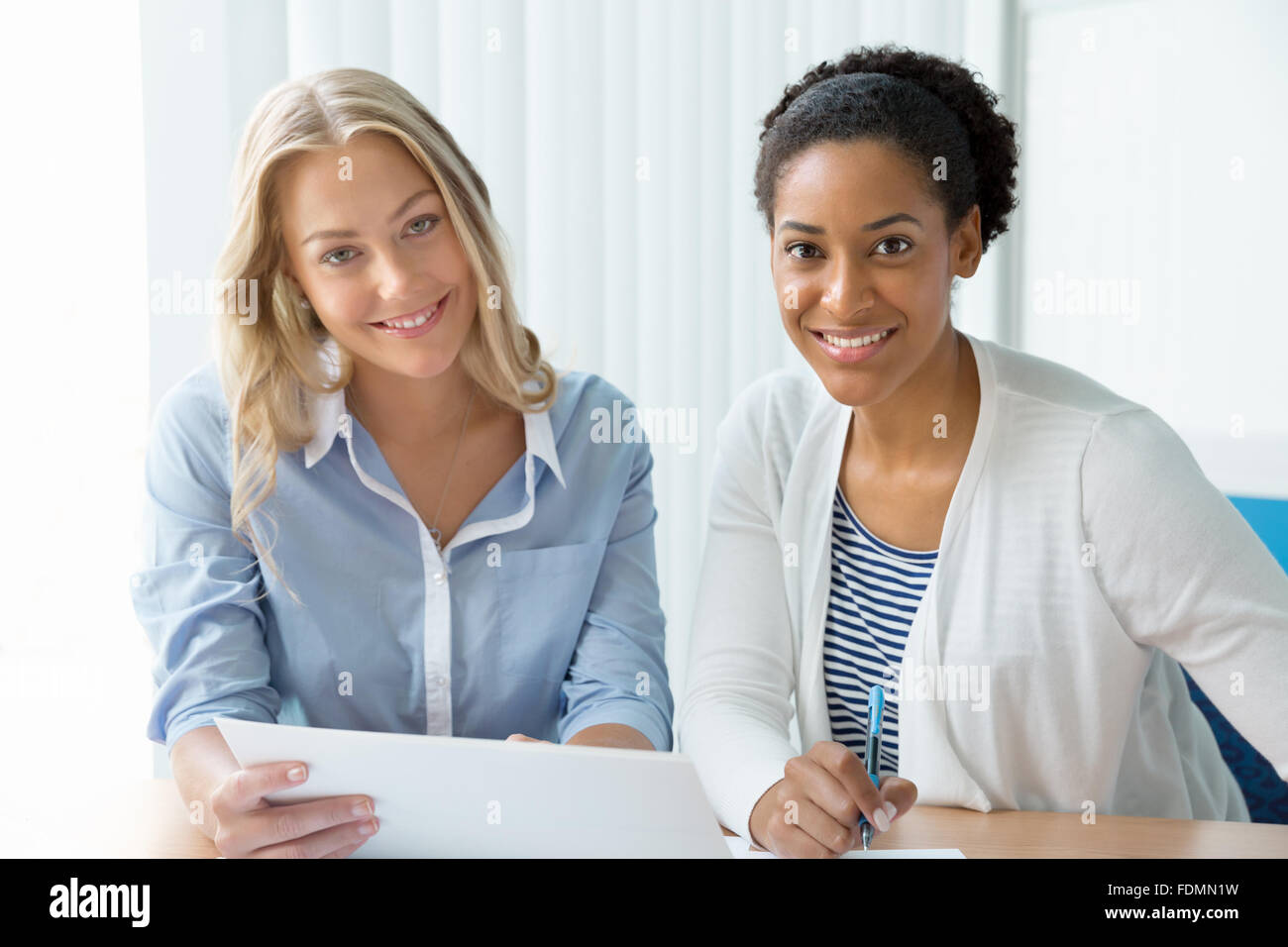 Two women working together in office Stock Photo - Alamy