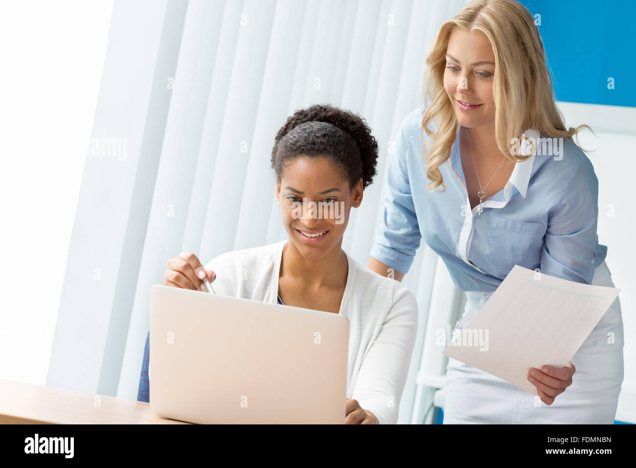 Two women working together in office Stock Photo - Alamy