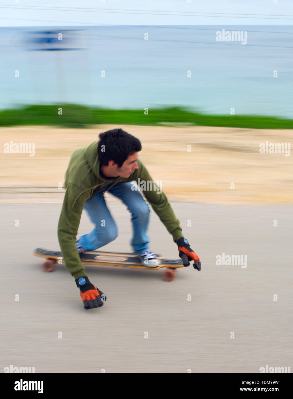 Blured motion of teenagers on a longboard going down the hill. Stock Photo