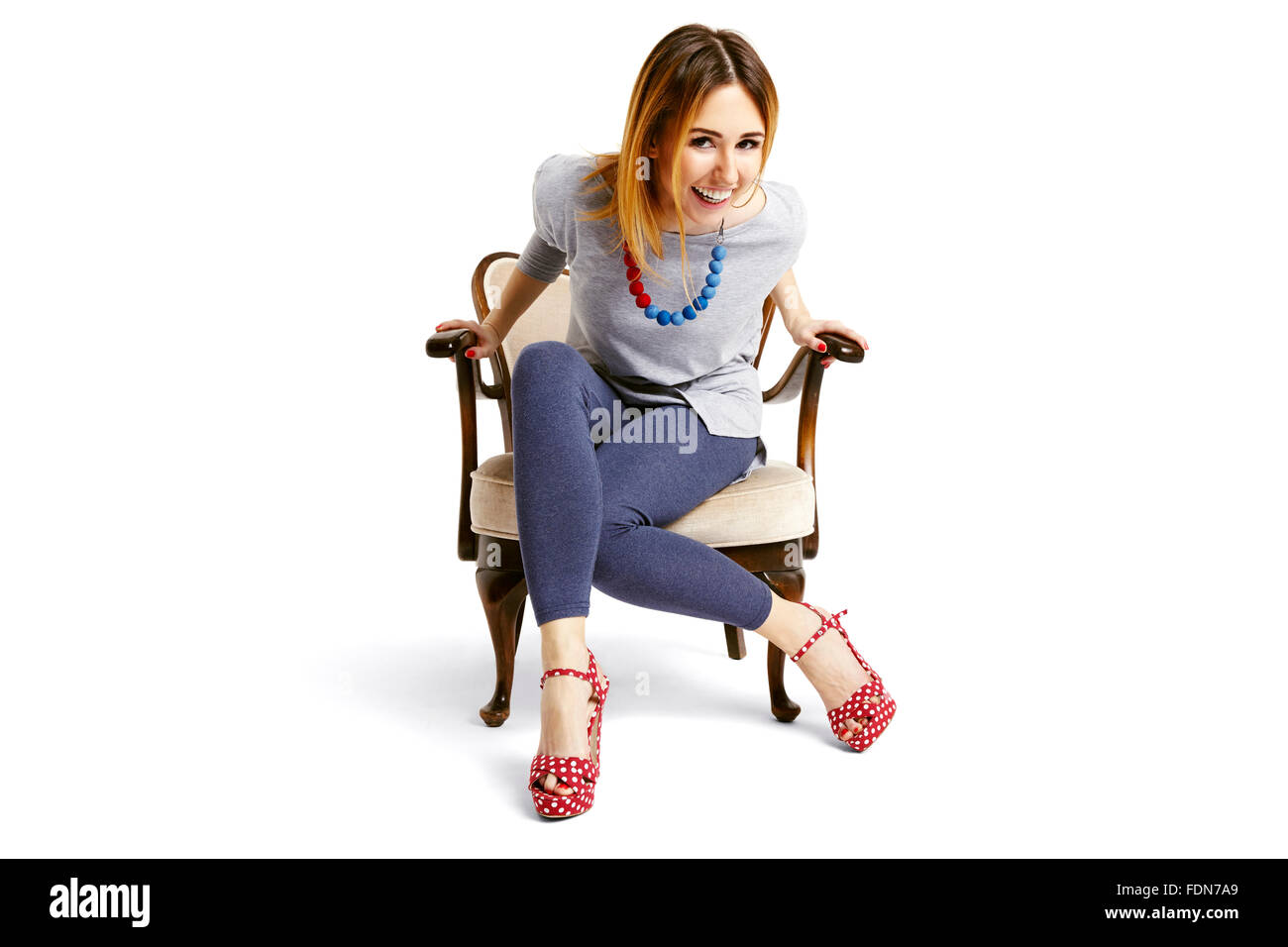 Woman sitting down on a old school chair and laughing Stock Photo