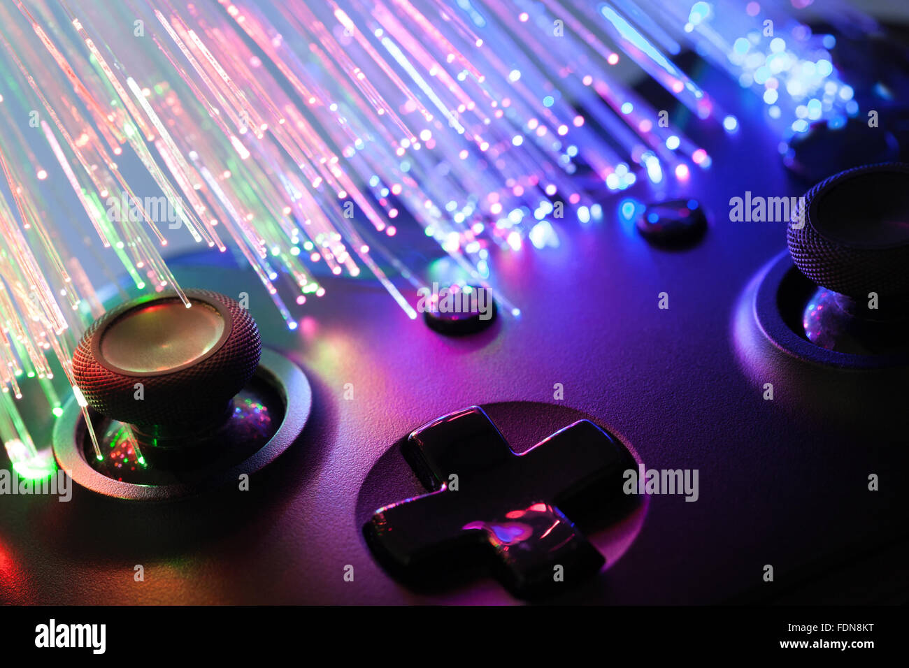 Black gamepad with optical cables next to it - studio shot Stock Photo