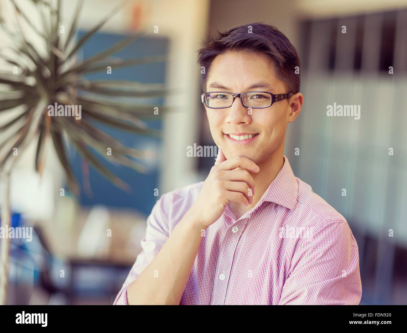 Portrait of young businessman standing in office Stock Photo - Alamy