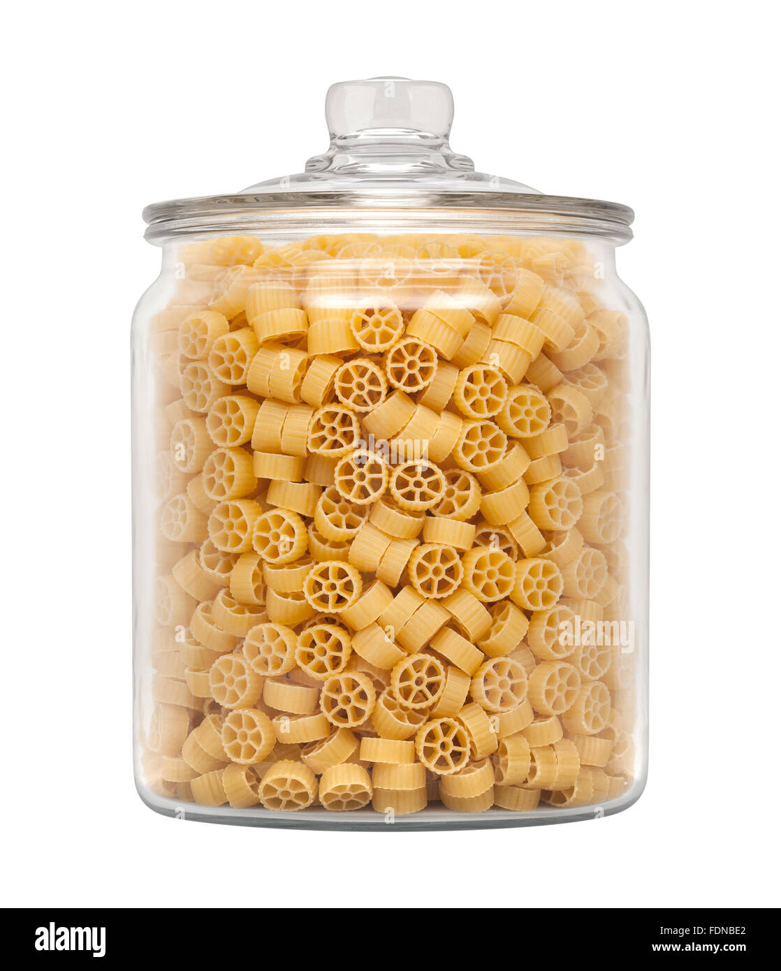 Mini Wheel Pasta in a Glass Apothecary Jar. The image is a cut out, isolated on a white background. Stock Photo