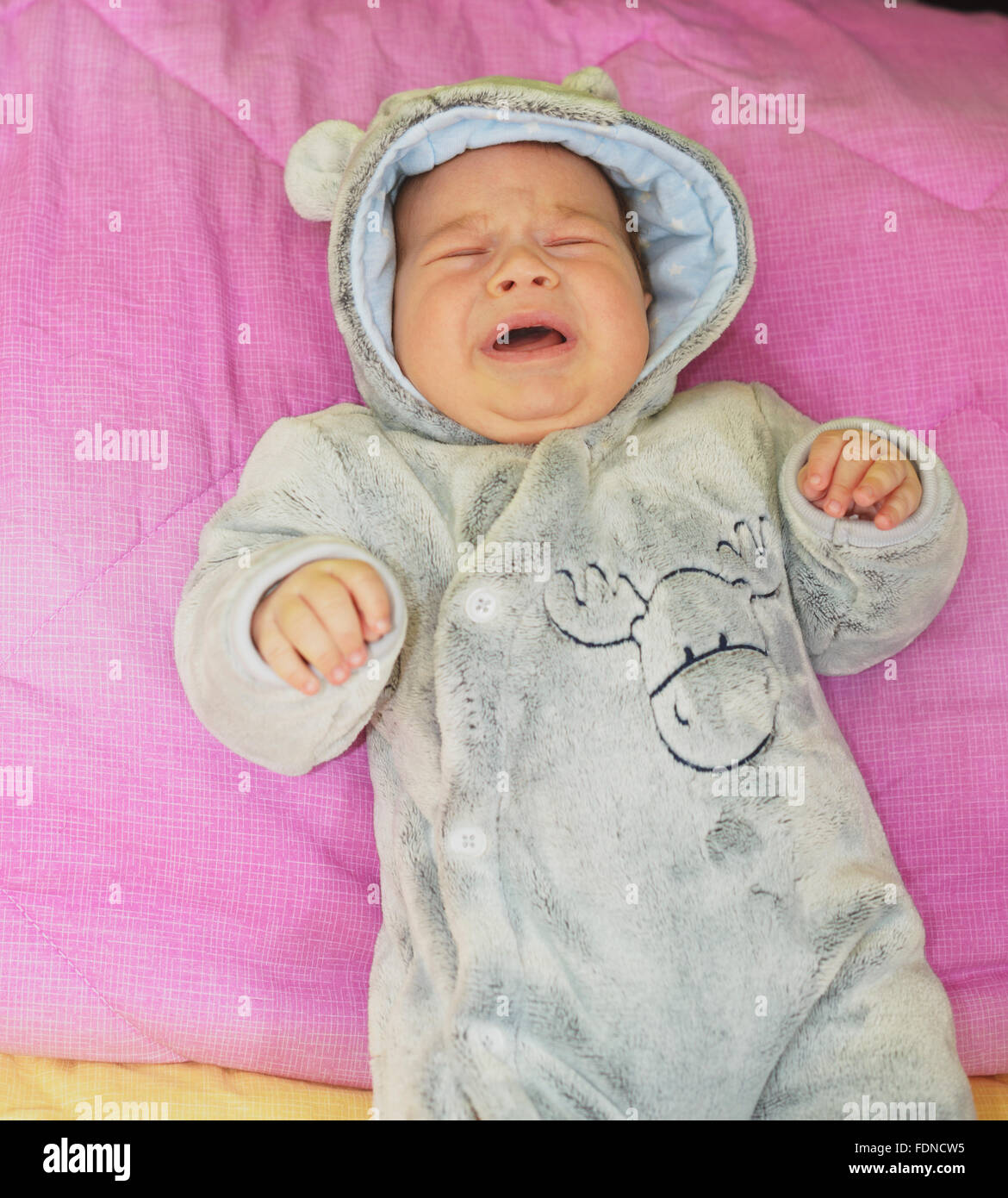newborn baby boy crying in his bed Stock Photo
