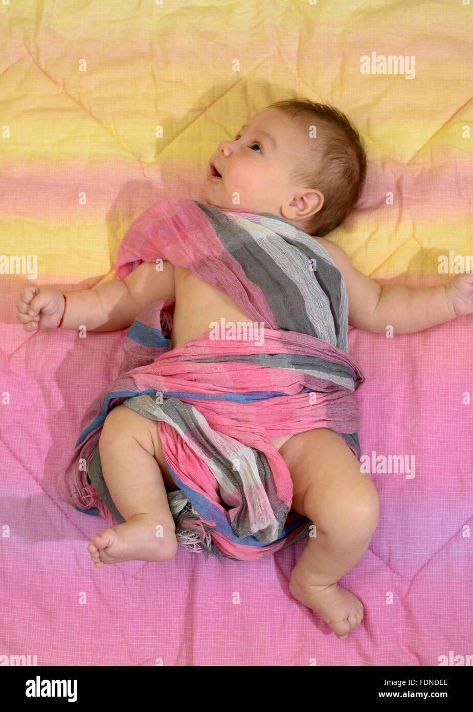 Newborn baby boy wrapped in a pink scarf Stock Photo