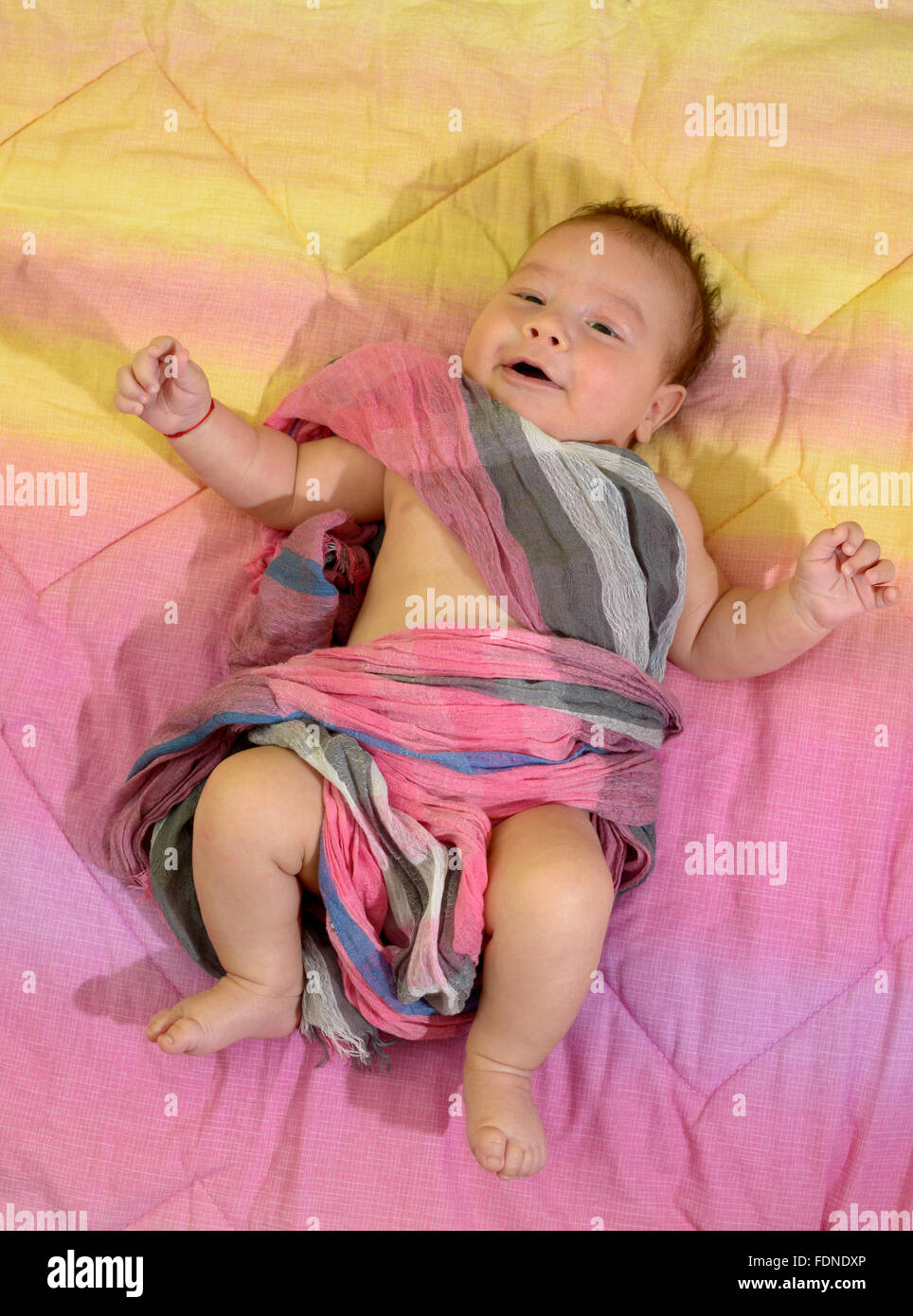 Newborn baby boy wrapped in a pink scarf Stock Photo