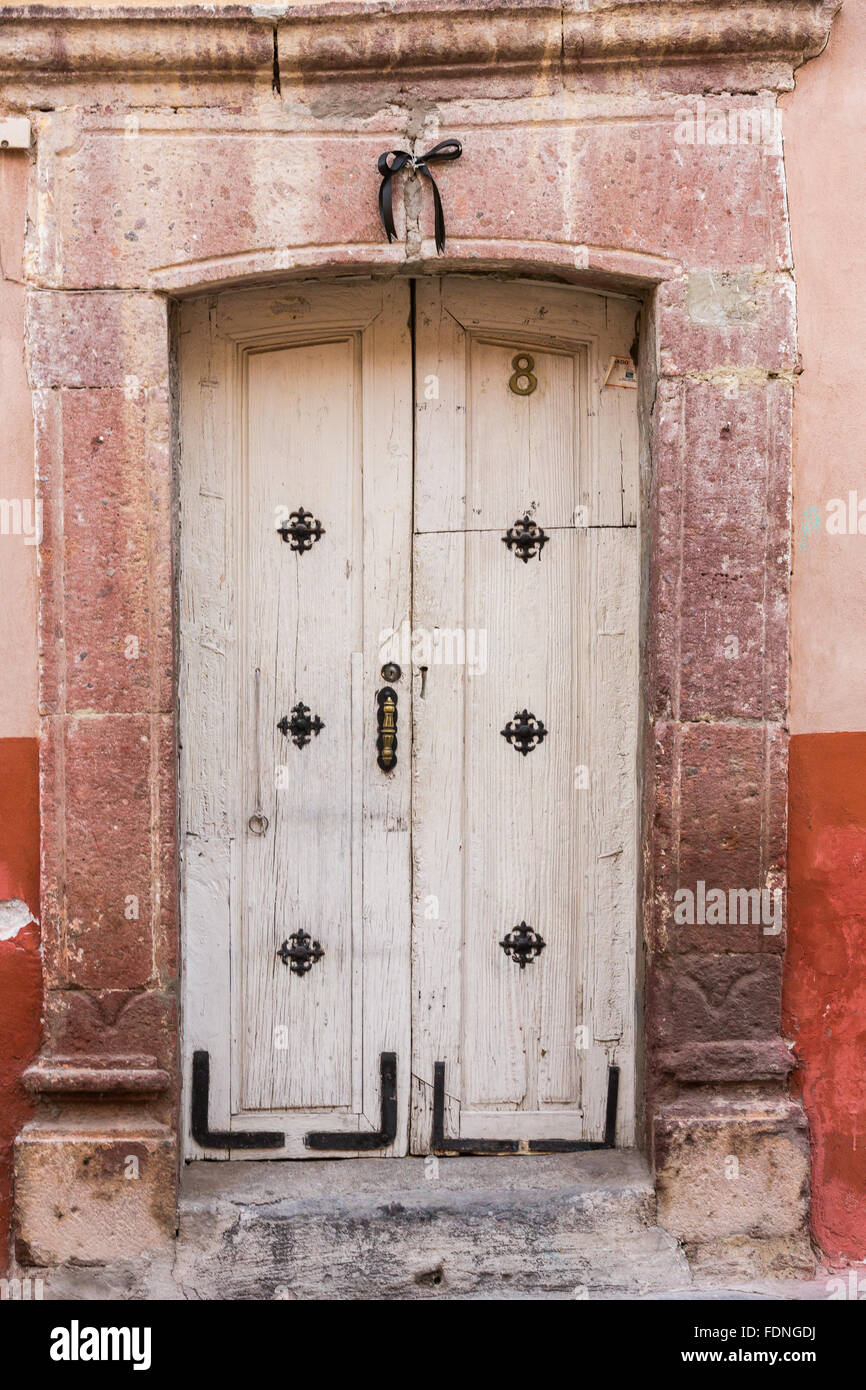A traditional hacienda style painted wooden door on a historic home in San Miguel de Allende, Mexico. Stock Photo