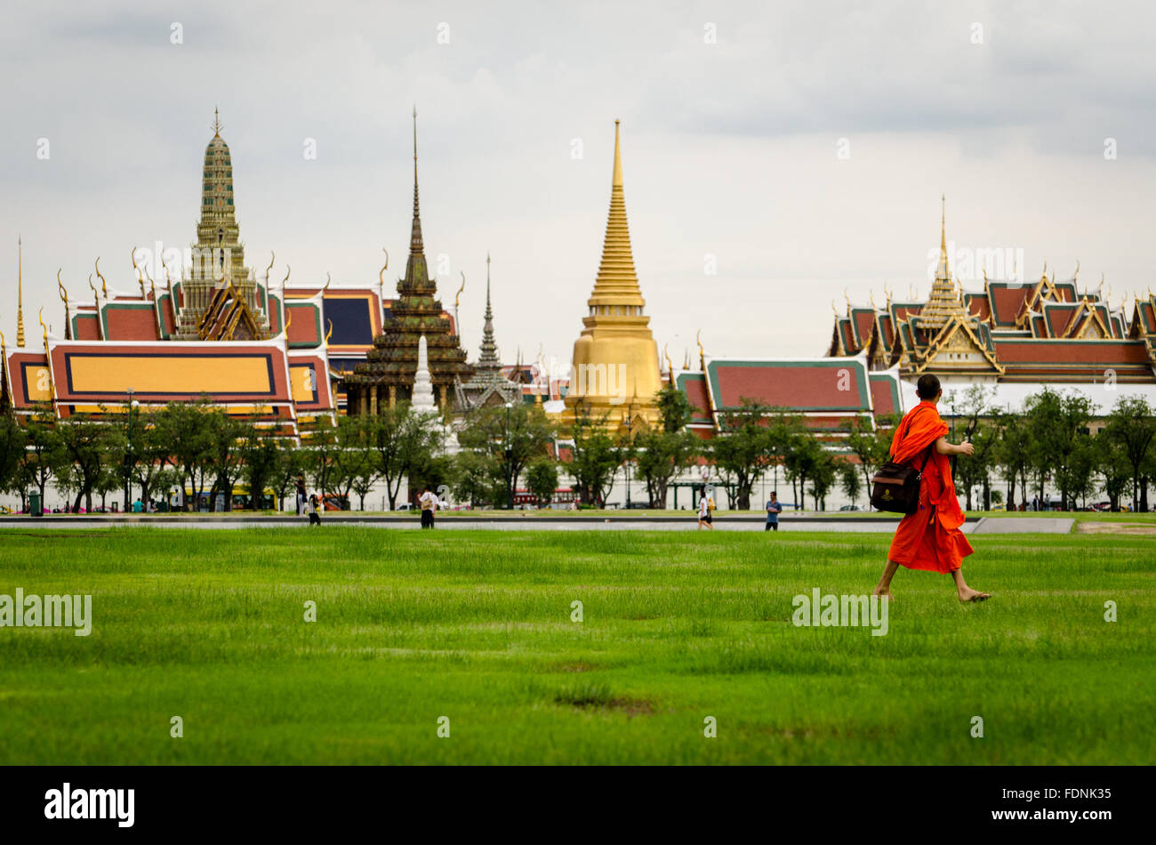 Bangkok, Bhuddist monk walking in Sanam Luang park with Wat Phra Kaeo in the background Stock Photo