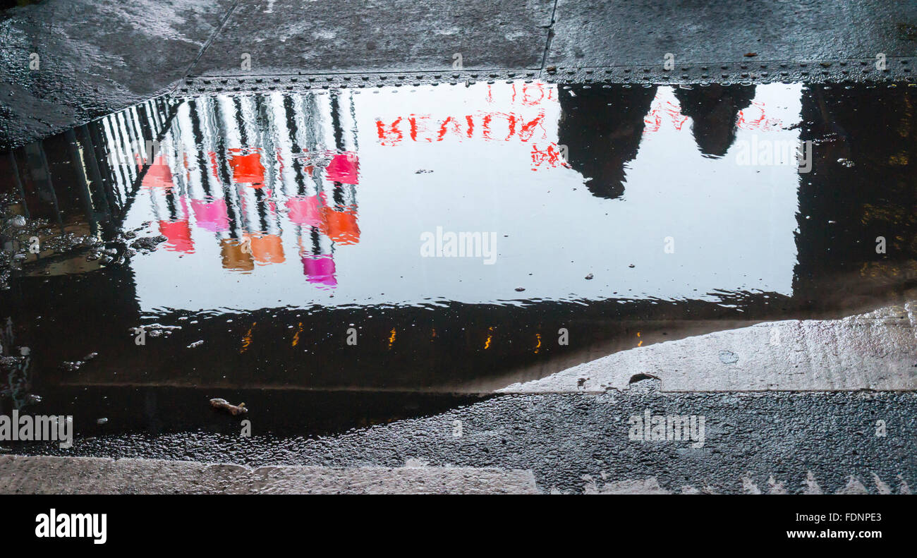 Advertising for Revlon reflected in a puddle in Times Square in New York on Tuesday, January 26, 2016. The Conference Board announced that consumer confidence rose to 98.1 in January up from 96.3 in December. The index is considered a barometer of the economy. (© Richard B. Levine) Stock Photo