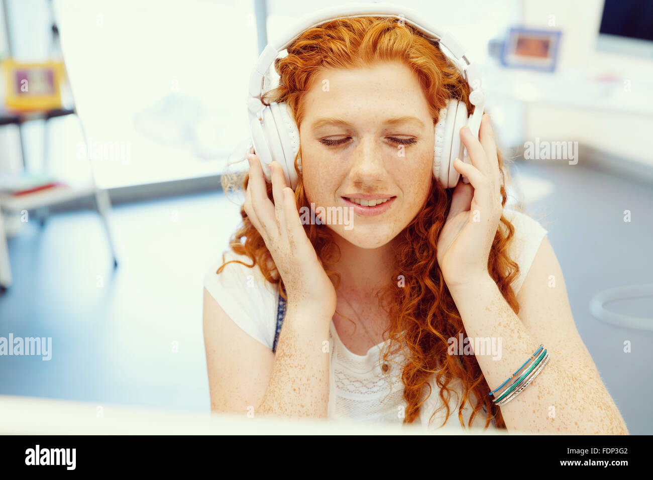 Young woman with headphones working in office at her desk Stock Photo ...