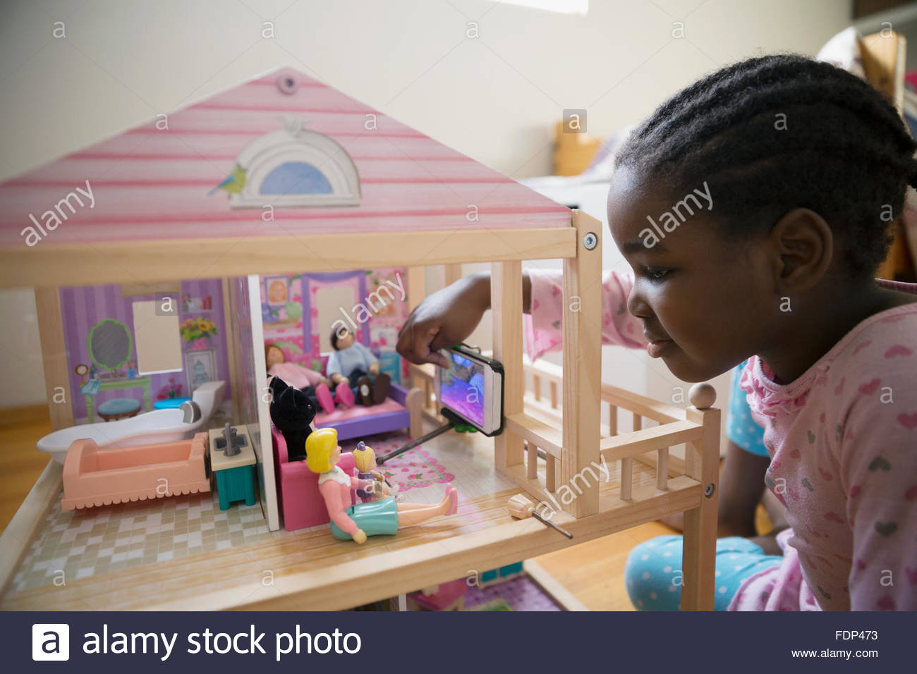 Girl photographing dolls in dollhouse Stock Photo Alamy