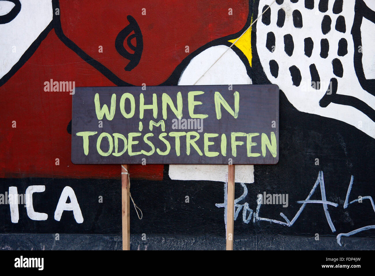 'Wohnen im Todesstreifen' - Protestplakate an einem Mauerstueck der Berliner Eastside Gallery, an dem ein Stueck fuer eine Zufah Stock Photo