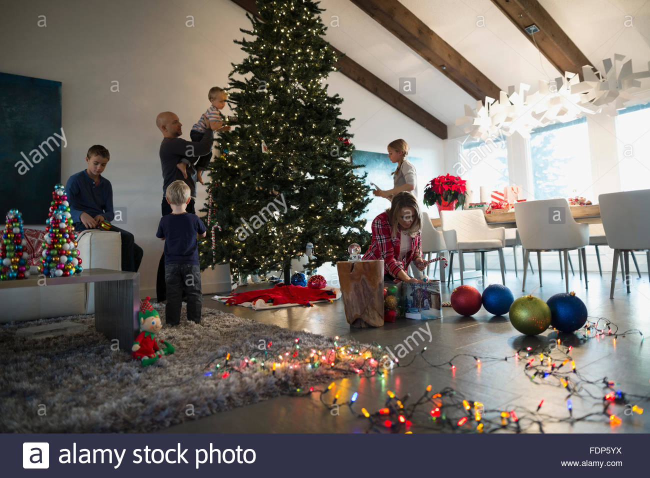 Family decorating Christmas tree in living room Stock Photo