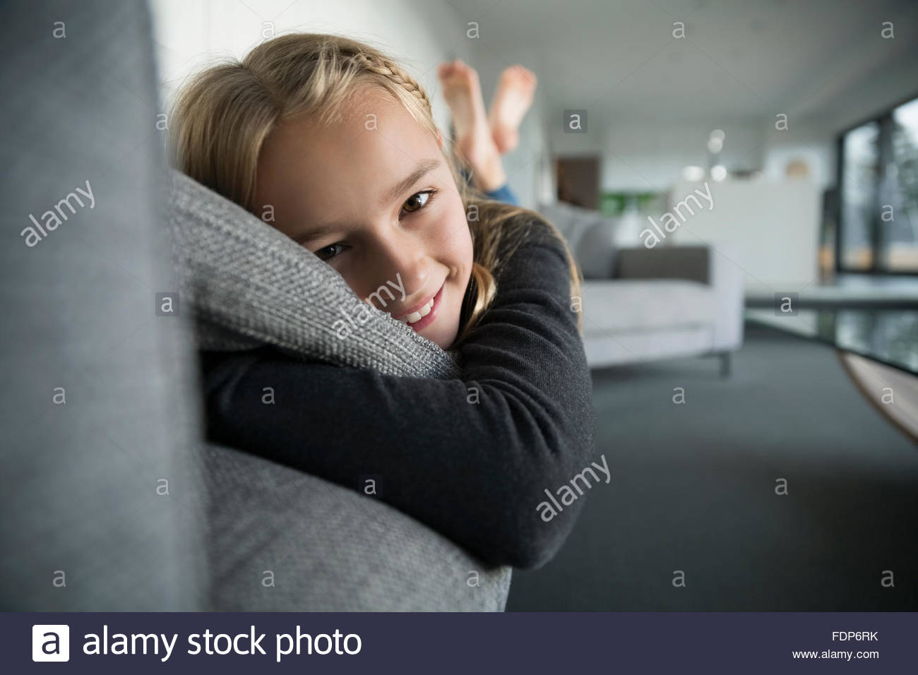 Portrait smiling girl laying on sofa Stock Photo