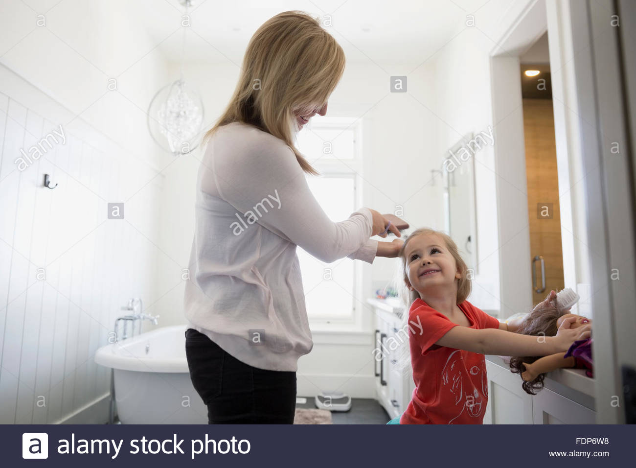 mother brushing daughters hair bathroom Stock Photo