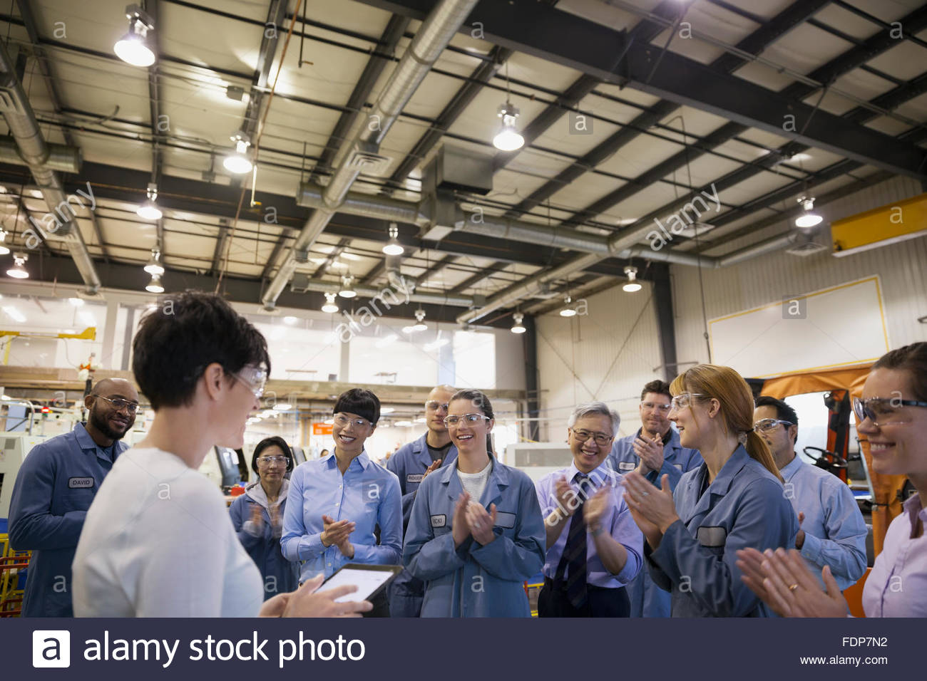 Workers clapping for manager in team meeting factory Stock Photo