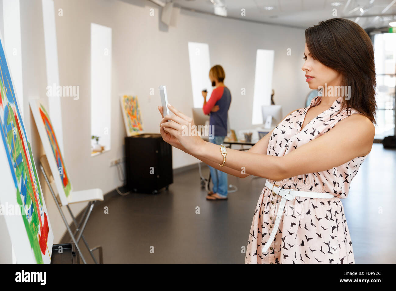 Portrait of pretty young woman standing in gallery Stock Photo - Alamy