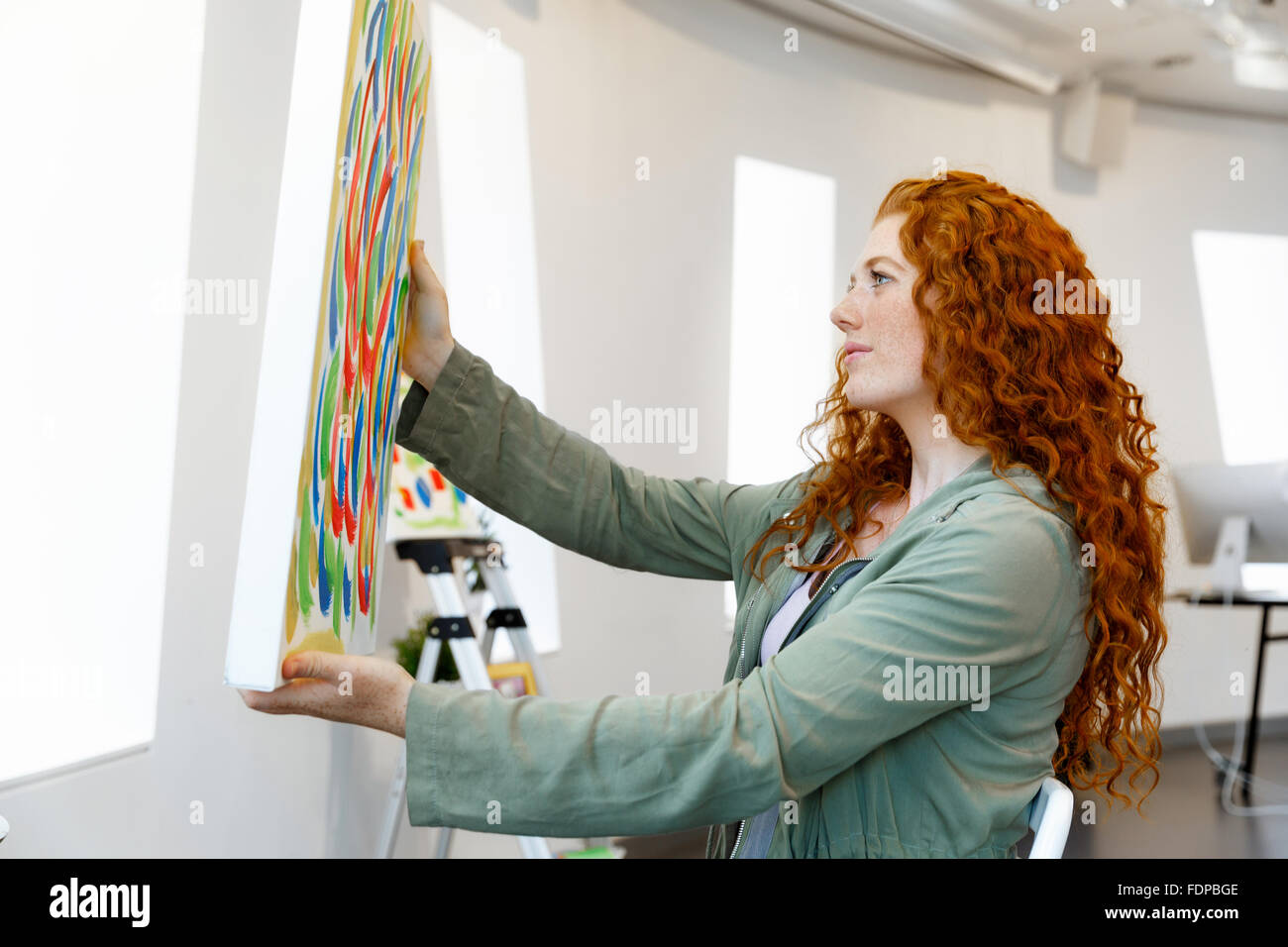 Young female artist in gallery with her picture Stock Photo - Alamy