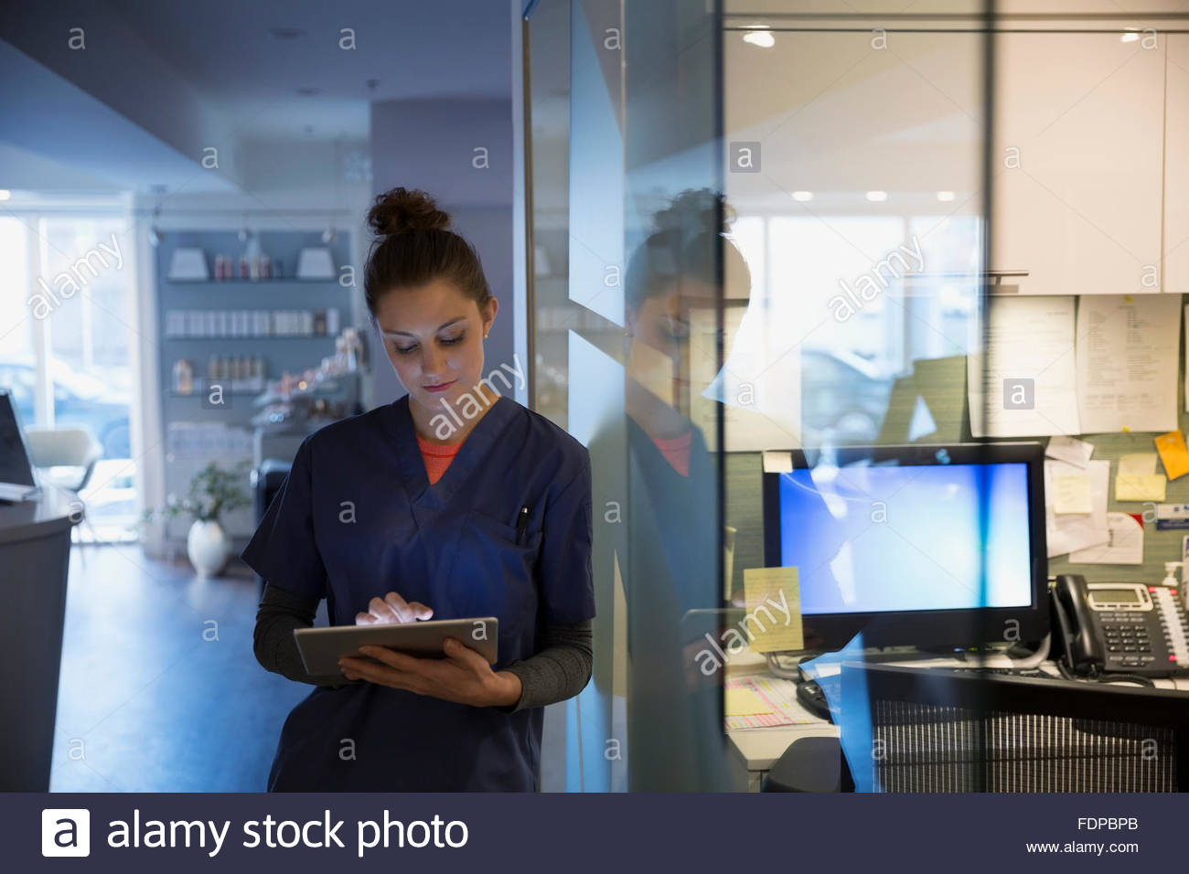 Nurse using digital tablet at nurses station Stock Photo