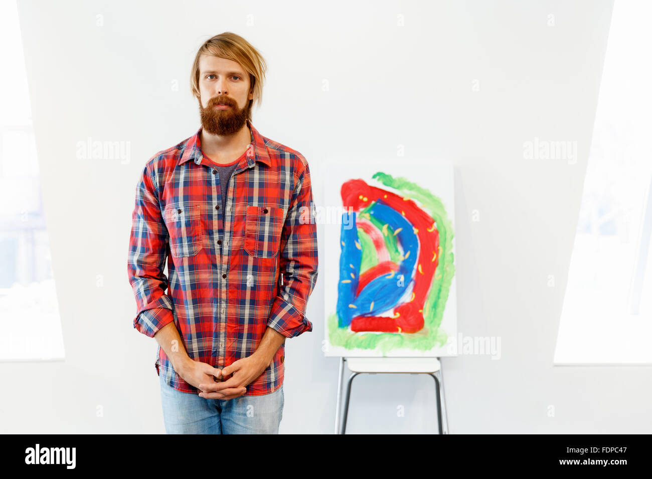 Young male artist standing with his picture Stock Photo - Alamy