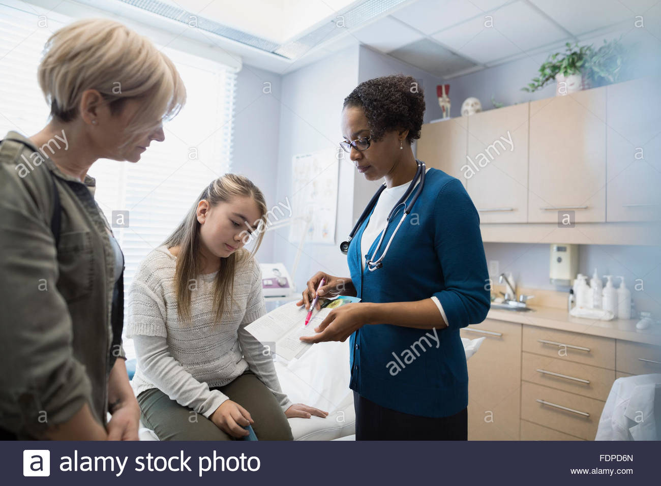 Pediatrician discussing results with patient and mother Stock Photo