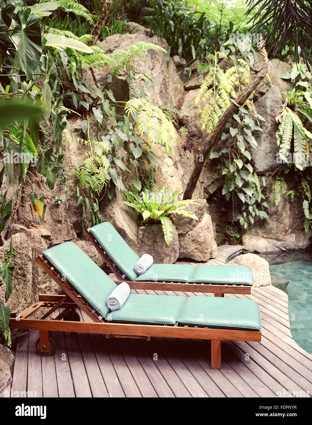 poolside lounge chairs on Two Poolside Lounge Chairs Welcome Guests To Relax By A Waterfall Pool At The Farm At San Benito Philippines Stock Photo Alamy