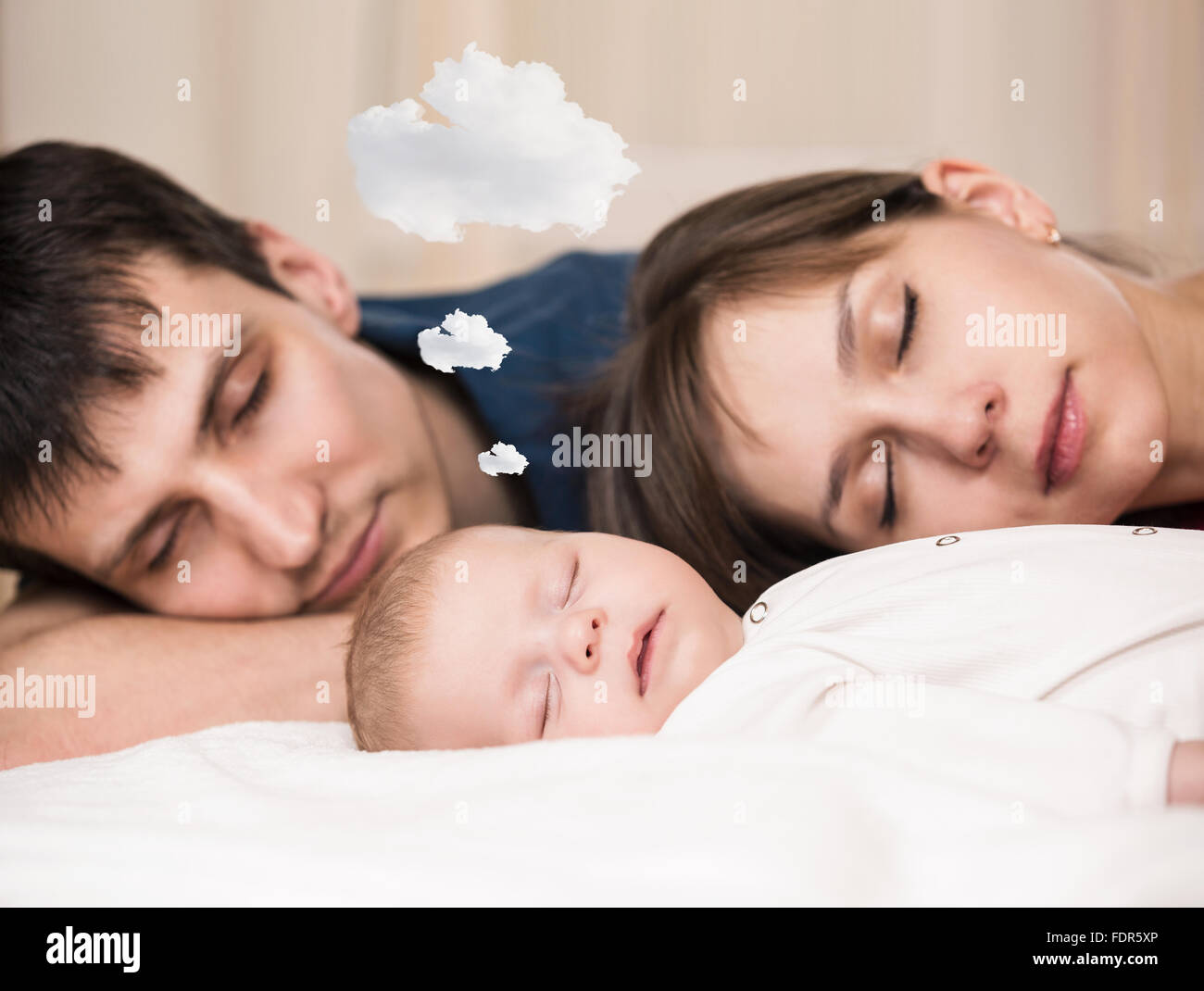 Baby sleeps  with tired parents Stock Photo