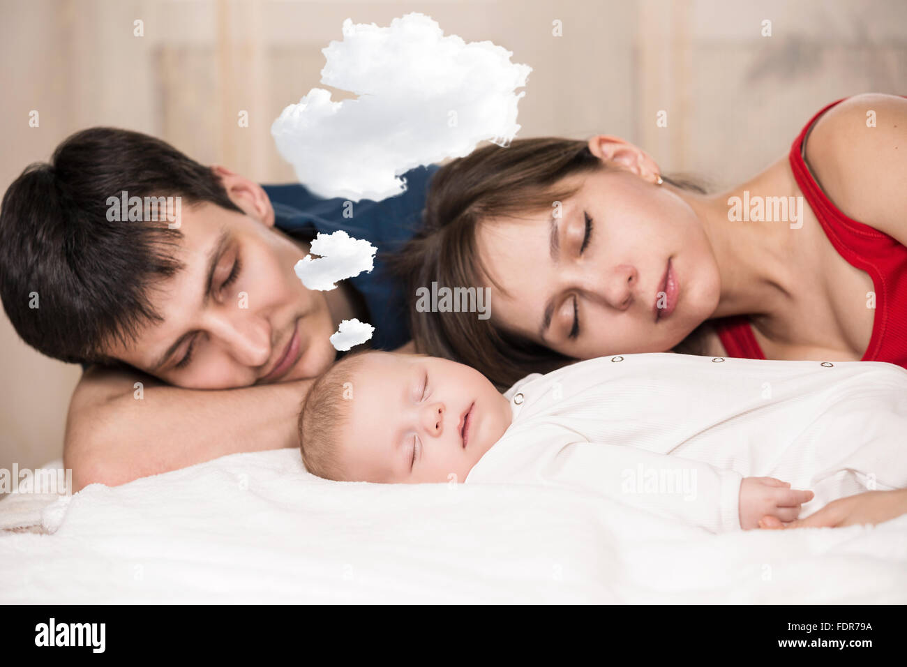 Baby sleeps  with tired parents Stock Photo