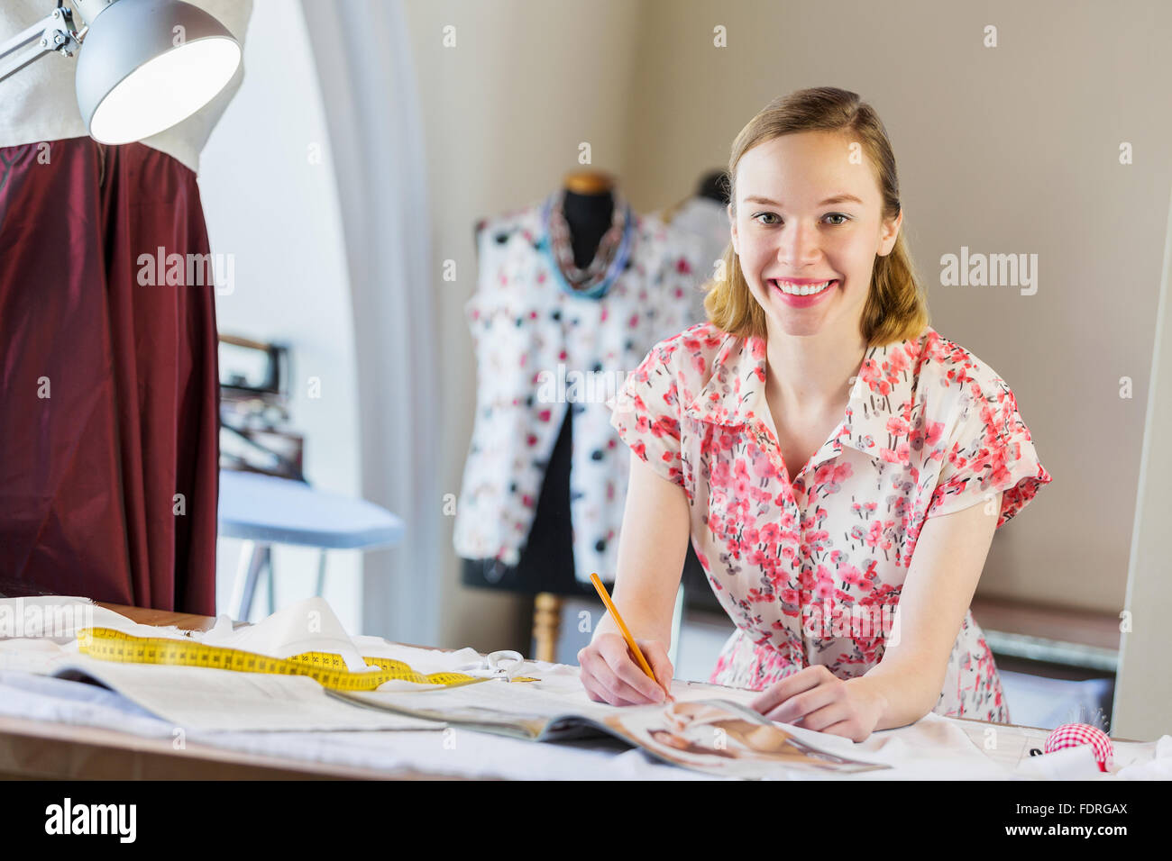 Pretty dressmaker at work making patterns of fabric Stock Photo - Alamy