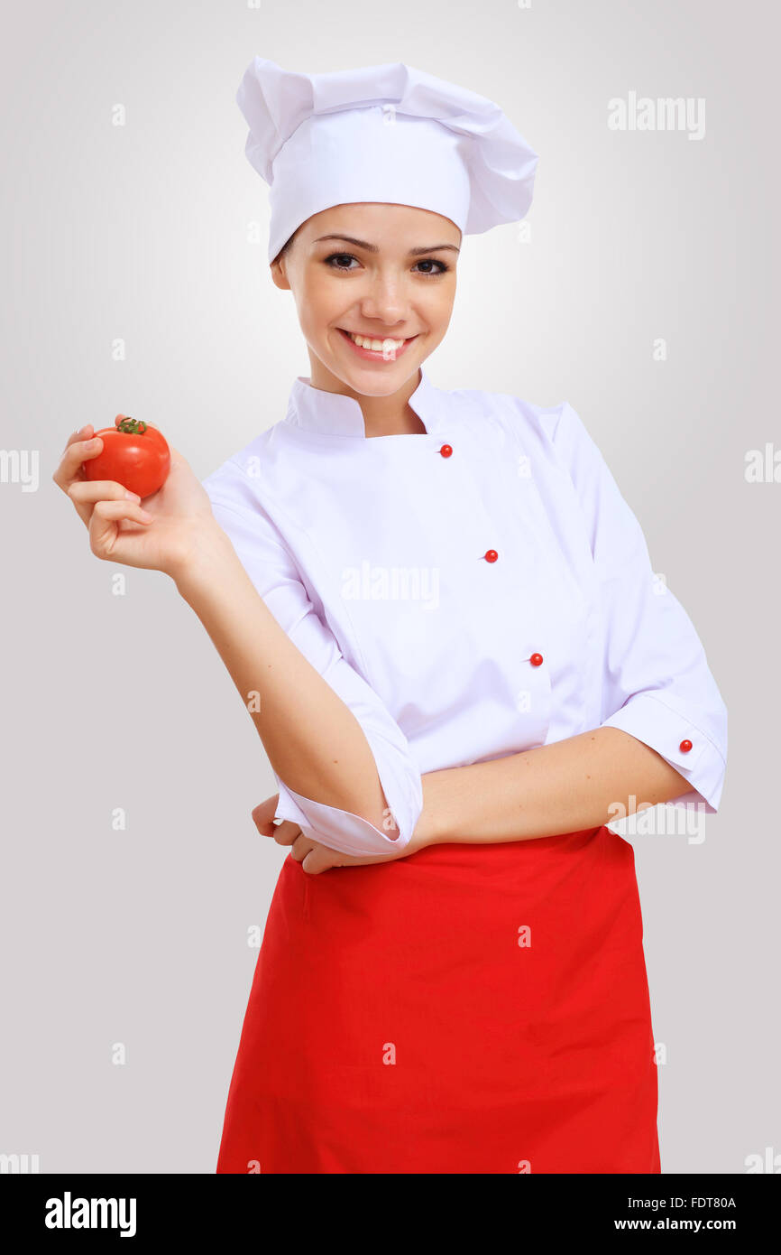 Young female chef in red apron against grey background Stock Photo Alamy