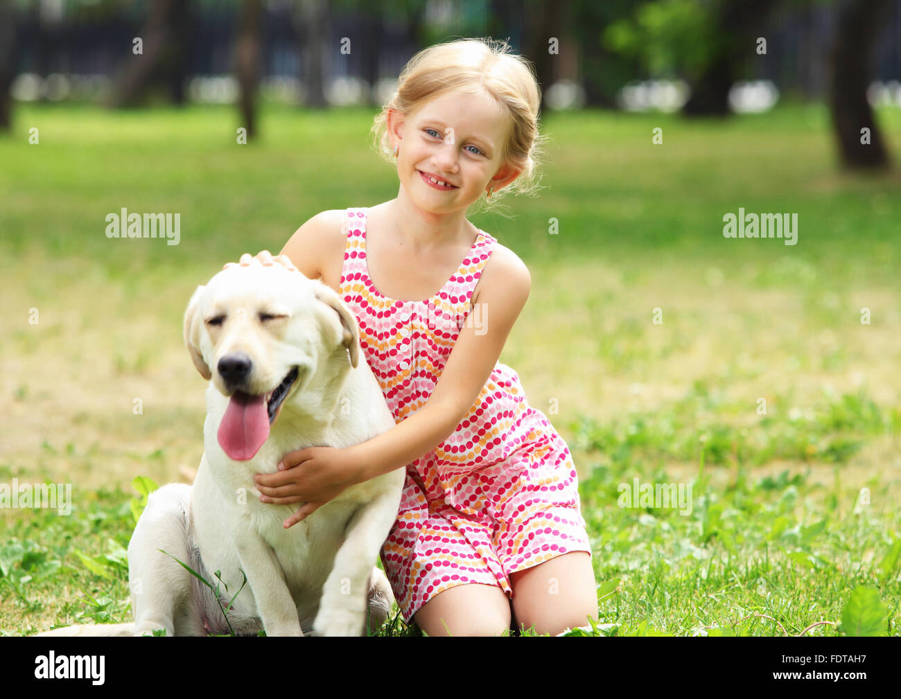 A little blond girl with her pet dog outdooors in park Stock Photo - Alamy