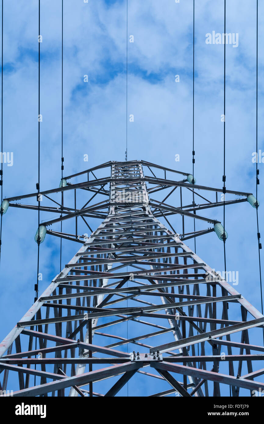 Power pole with high voltage against the blue sky Stock Photo