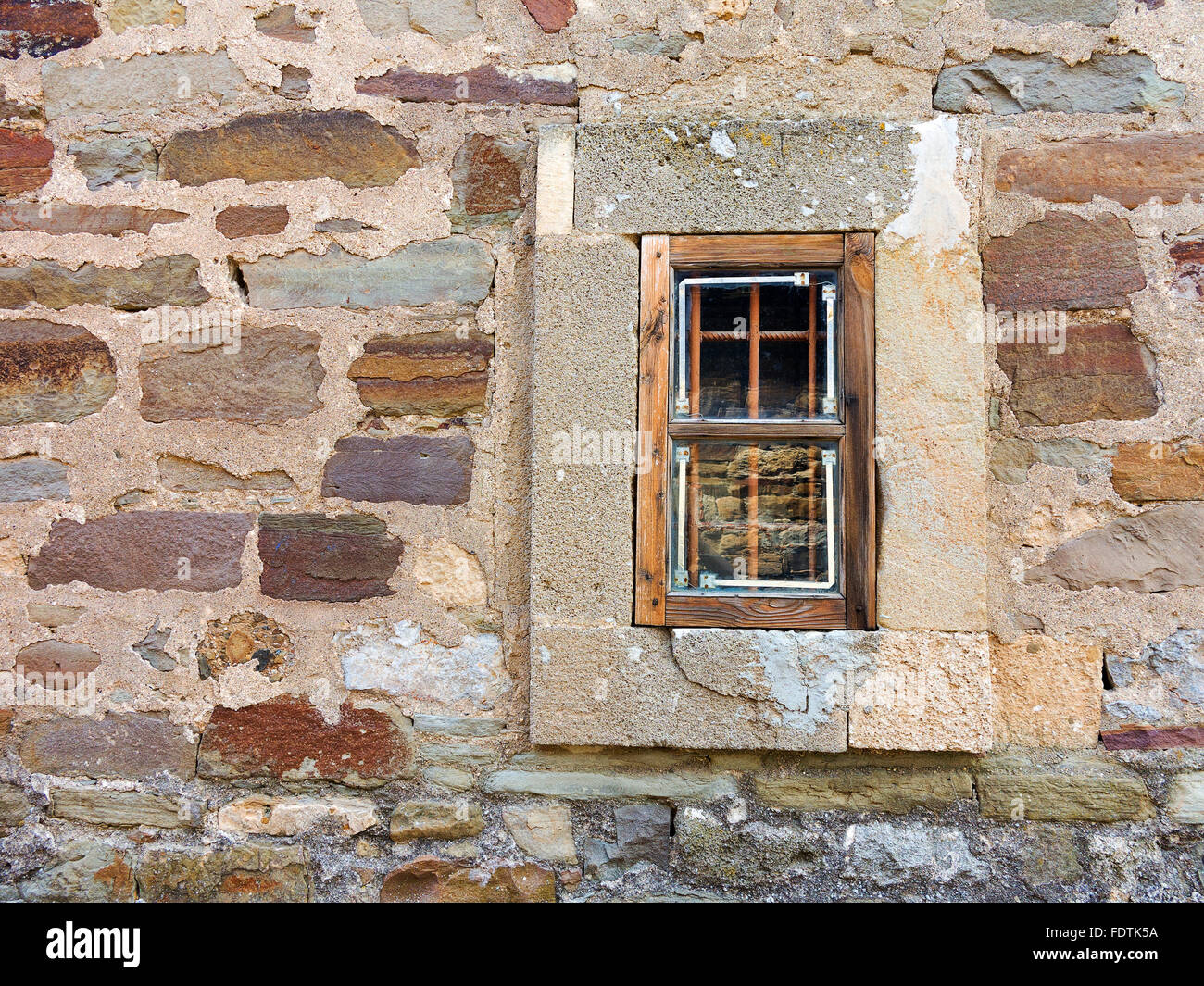 Old window with creative metal bars on the white stone wall Stock Photo ...