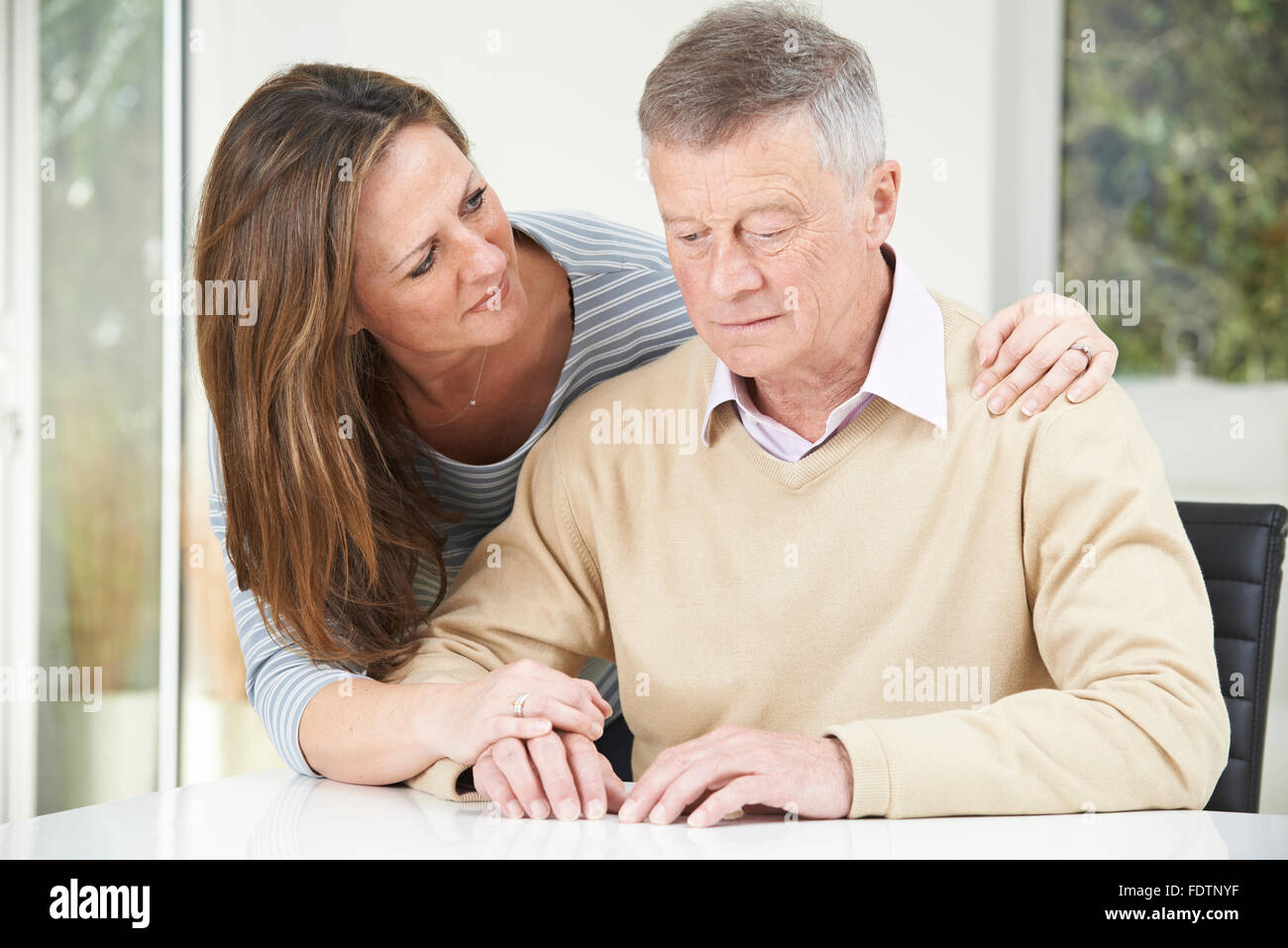 Confused Senior Man With Adult Daughter At Home Stock Photo