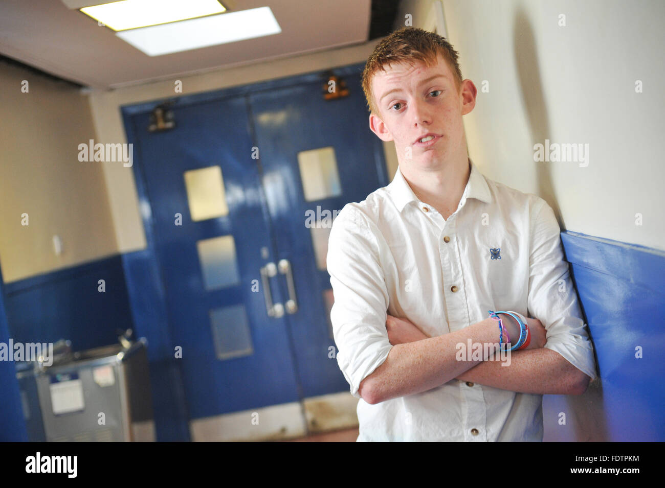 Ginger teenage boy school pupil poses in corridor. Stock Photo