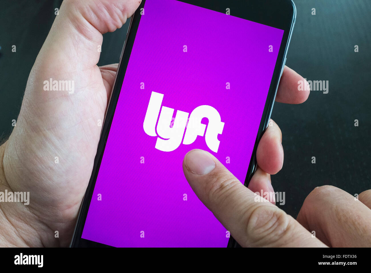 Lyft online taxi booking app logo on screen of smart phone Stock Photo