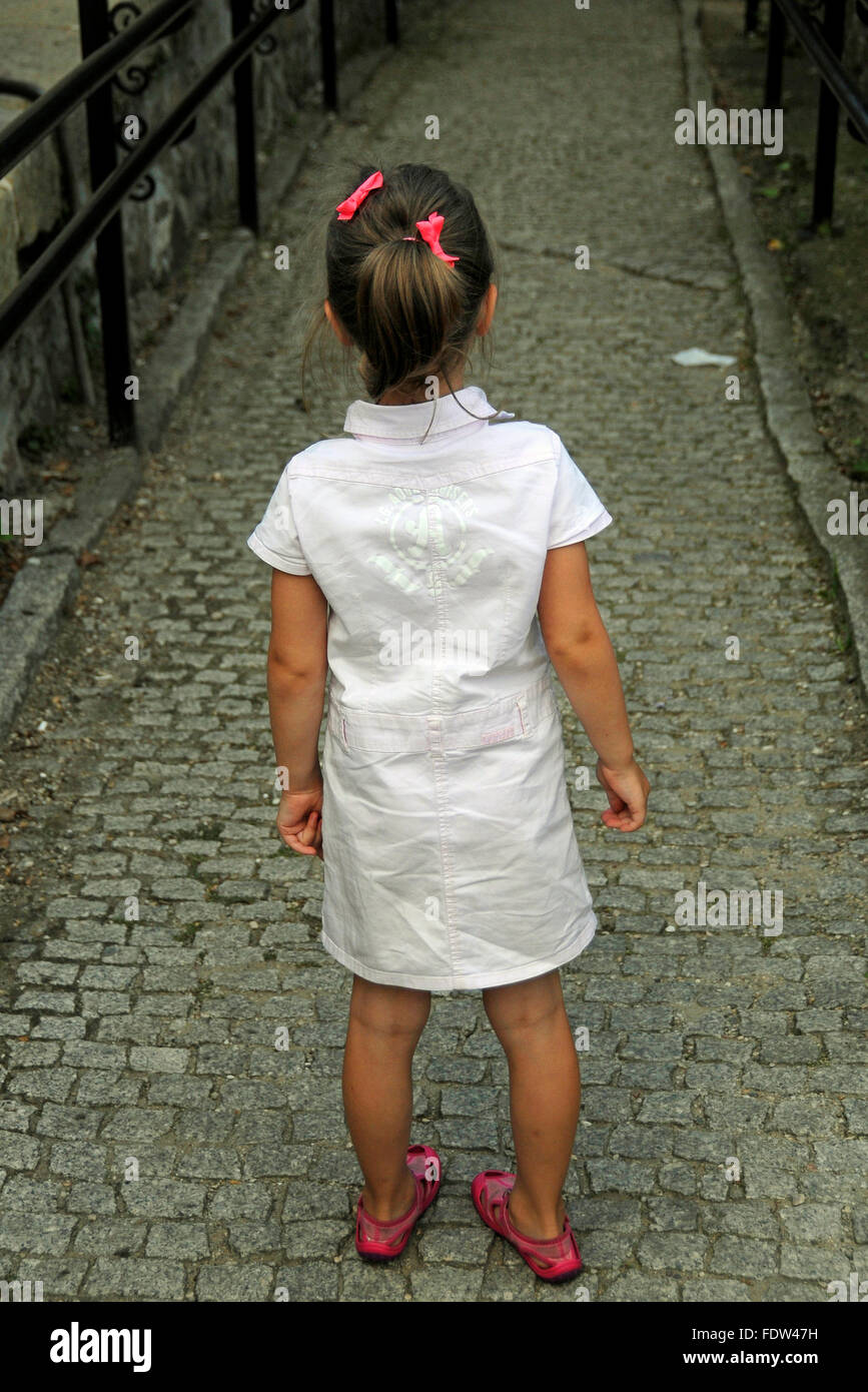 Little girl standing with long paved bricked road ahead of her at Ksiaz Castle, near Walbrzych Poland Stock Photo