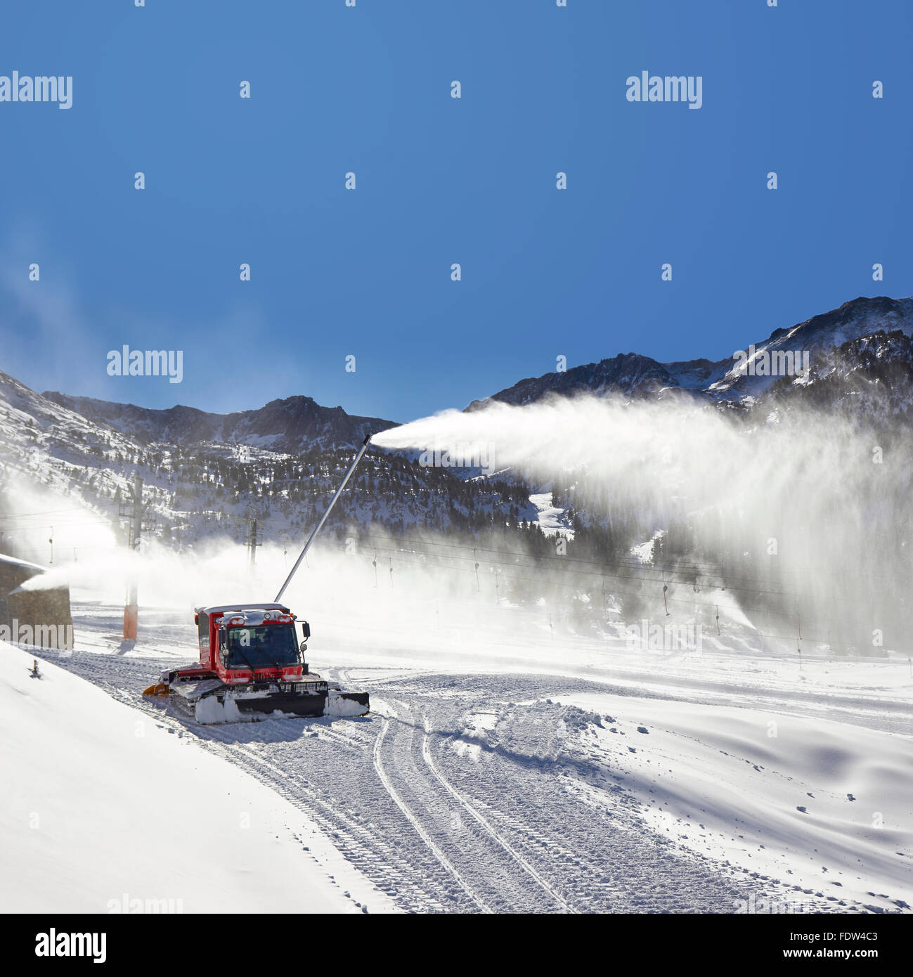 Preparation of ski resort in Pyrenees by red ratrack vehicle and snow canon, Andorra, Europe Stock Photo